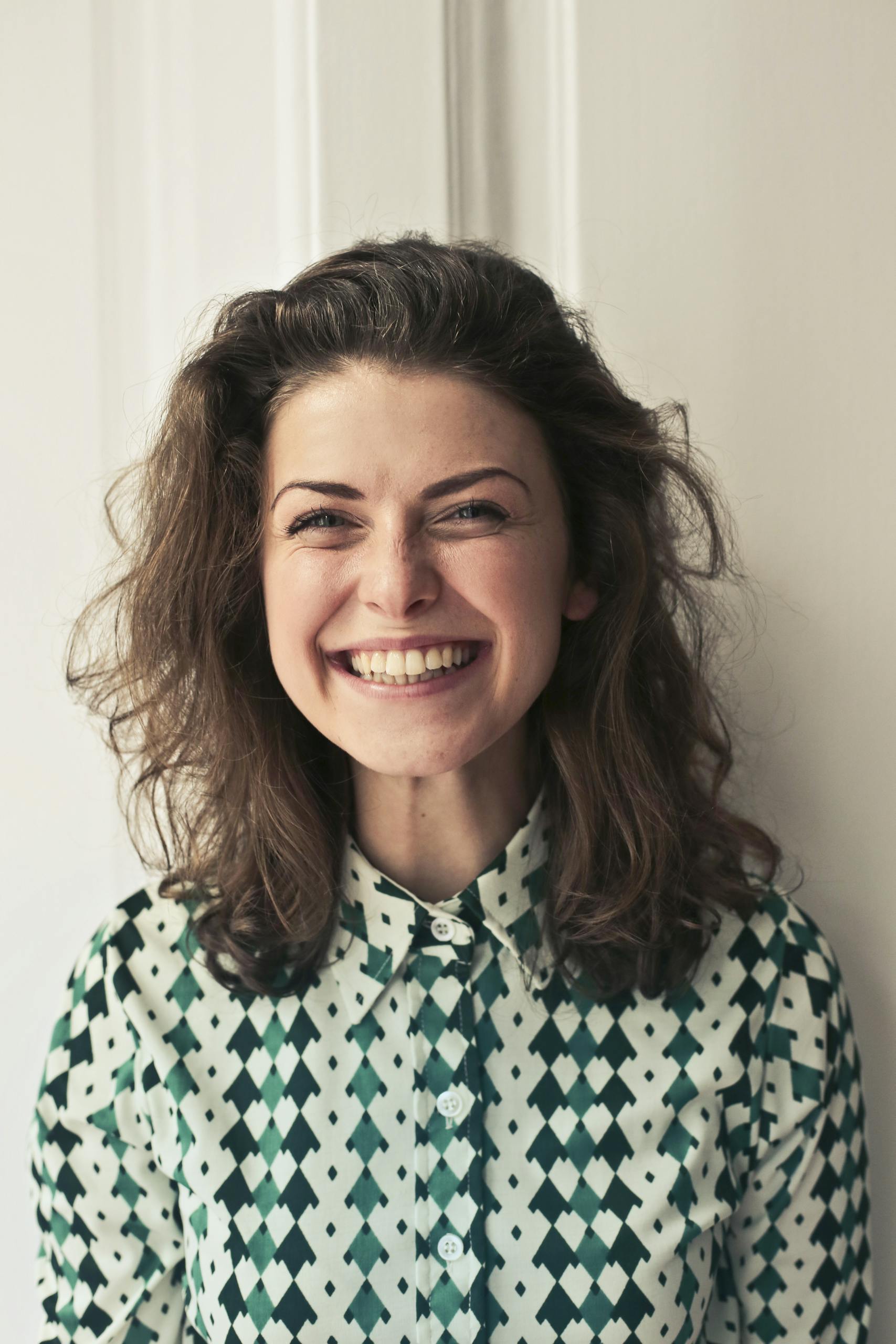 portrait-of-a-joyful-brunette-woman-with-a-vibrant-smile-indoors-capturing-happiness-and-positivity